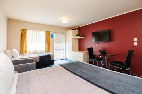 a hotel room with a bed and a tv at Braemar Motor Lodge in Palmerston North