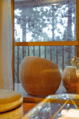 two wicker chairs sitting in front of a window at 箱根 邂逅 ログハウス 森林浴とBbqが楽しめる in Ashinoyu