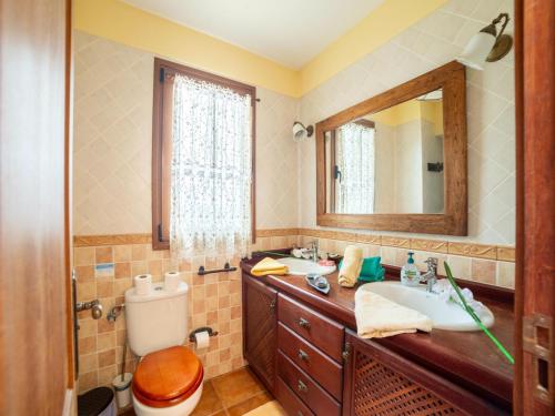 a bathroom with two sinks and a toilet and a mirror at Villa in Tenerife with Pool and Sea Views in Teno Alto