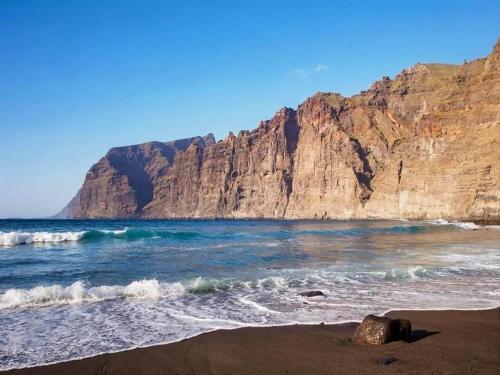 a beach with a rocky mountain in the background at Villa in Tenerife with Pool and Sea Views in Teno Alto