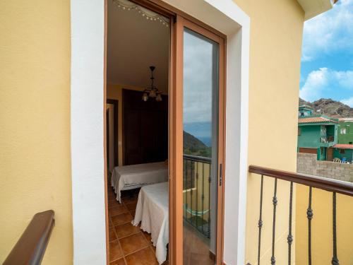 a balcony with a sliding glass door with a view of a bed at Villa in Tenerife with Pool and Sea Views in Teno Alto