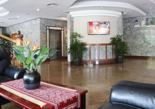 a lobby with a table with a vase on it at Grand Palace Hotel in Miri
