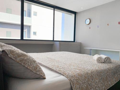 a bedroom with a bed with two towels on it at Depa Puerto Santana,AC,WIFI,Bares,Restaurante,segurida 24-7 in Guayaquil