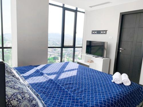 a bedroom with a blue bed with towels on it at Depa Puerto Santana,AC,WIFI,Bares,Restaurante,segurida 24-7 in Guayaquil