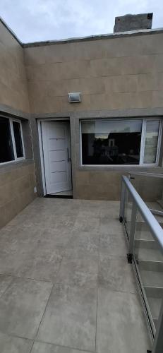 a garage with a white door and a building at Como en casa CRD 2 in Comodoro Rivadavia