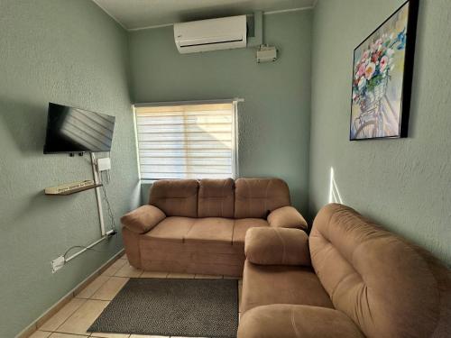 a living room with a couch and a television at Sweet Home - Seguridad, Piscinas, Parques y Paz in San Miguel