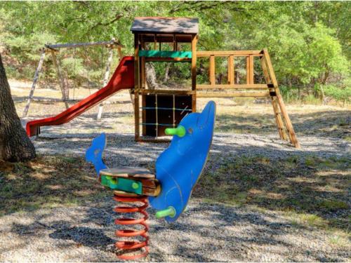 a playground with a slide and a swing at Mobil-home à Esparron-de-Verdon - 2 chambres, terrasse - API-1-52-578 in Esparron-de-Verdon