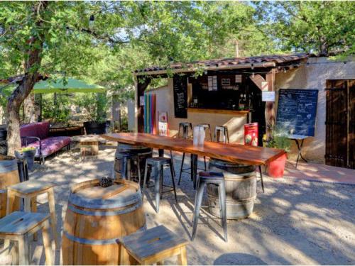 a wooden table and some chairs and a table and barrels at Mobil-home à Esparron-de-Verdon - 2 chambres, terrasse - API-1-52-578 in Esparron-de-Verdon
