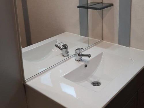 a white bathroom sink with a mirror above it at Chalet 3 chambres avec terrasse pour 5 personnes - API-1-52-617 in Rives