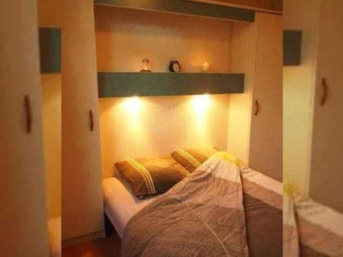 une chambre avec un lit avec une étagère au-dessus dans l'établissement Mobil-home 7 pers avec terrasse - API-1-52-737, à Esparron-de-Verdon