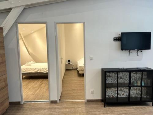 a room with a bedroom with a bed and a flat screen tv at Appartement 6 pers, 2 ch, cuisine équipée à Jumièges - API-1-52-703 in Jumièges