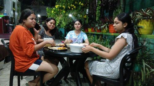 a group of women sitting at a table eating food at Green View Homestay in Siliguri