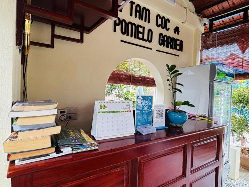 a desk with books and a computer on top of it at Tam Coc Pomelo Garden in Ninh Binh