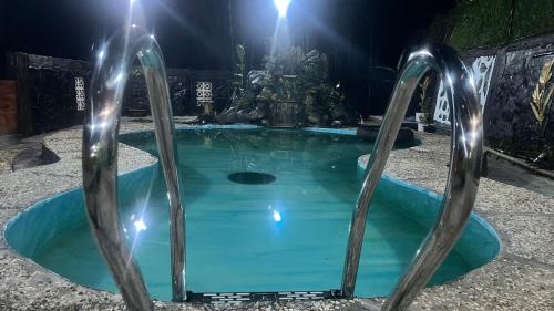Una pequeña piscina de agua azul con dos puertas de metal. en The Valley house cidwi resort, en Cicadas