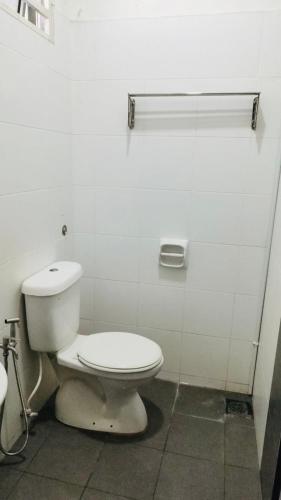 a white bathroom with a toilet in a room at ZuLee Homestay in Lunas