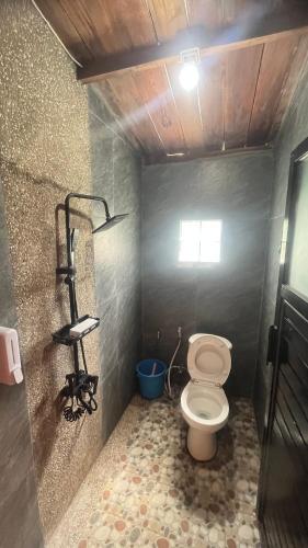 a small bathroom with a toilet in a stall at The Ci Dwi Resort in Cicadas