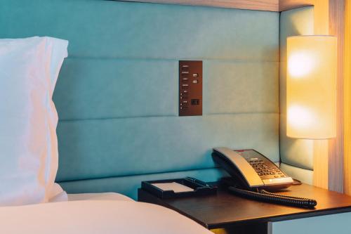 a phone on a desk next to a bed at The Prince Park Tower Tokyo - Preferred Hotels & Resorts, LVX Collection in Tokyo