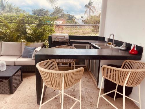 eine Küche mit Stühlen und einer Theke mit Spüle in der Unterkunft Casa Brisa in Lo de Marcos