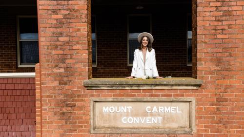 a woman sitting on a window ledge of a building at Rutherglen Convent in Rutherglen