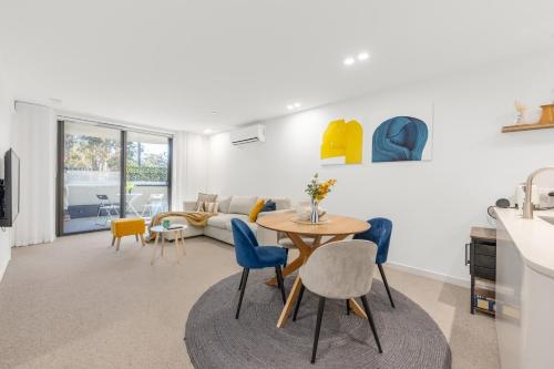 eine Küche und ein Wohnzimmer mit Tisch und Stühlen in der Unterkunft Chic Inner North Escape,Dickson n ANU ,Parking in Downer