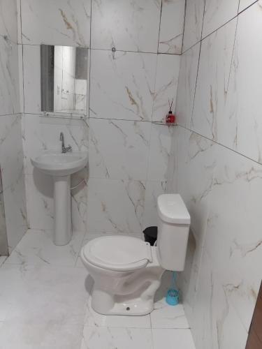 a white bathroom with a toilet and a sink at Casa em salinas in Salinópolis