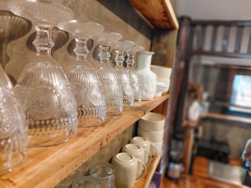 a row of glass vases and cups on a shelf at La Casita in El Nido