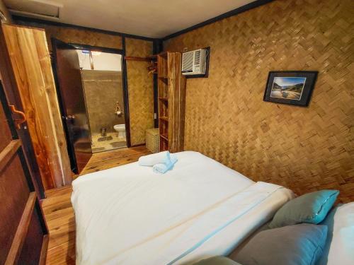 a bedroom with a large white bed in a room at La Casita in El Nido