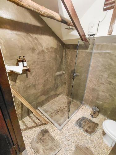 a bathroom with a shower and a toilet at La Casita in El Nido
