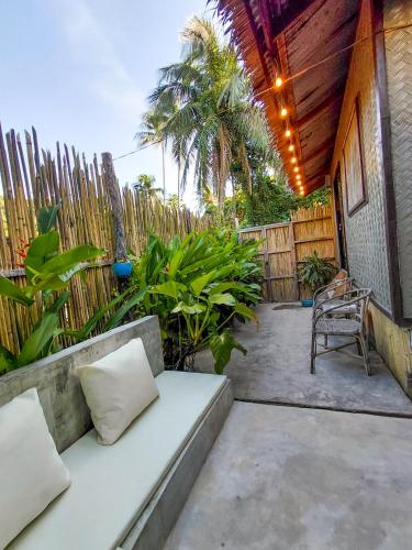 a patio with a couch and a fence at La Casita in El Nido