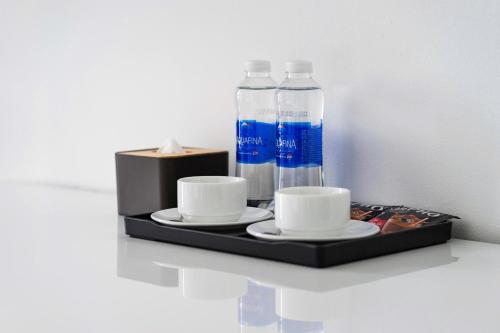 a tray with two cups and two bottles of water at Hoàng Anh Apartment in Da Nang