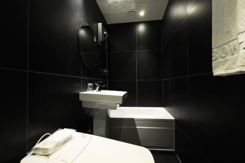a black bathroom with a sink and a toilet at Sindang Rainbow Hotel in Seoul