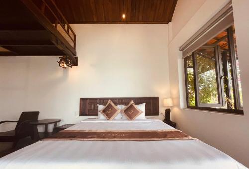 a bedroom with a bed and a window at La Y Riverview in Hue