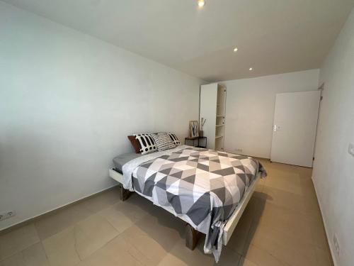 a bedroom with a bed in a white room at Pelikaan apartment - Regal Rentals Curacao in Grote Berg