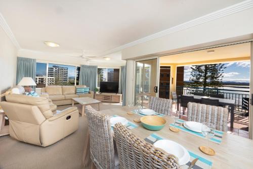 a living room with a table and chairs at Whitesands 402 in Forster