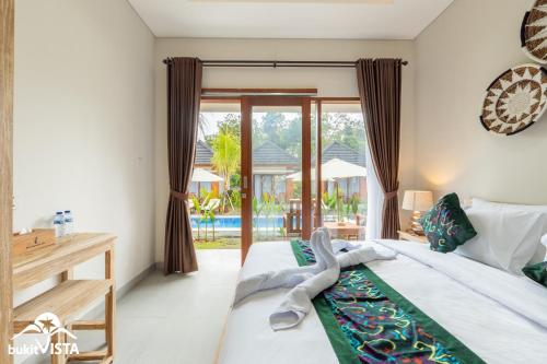 a bedroom with a bed and a view of a pool at Danu Sanctum Villas By Bukit Vista in Uluwatu