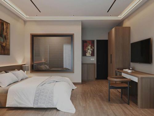Un dormitorio con una cama, un escritorio y un televisor. en Tam Cốc Phương Thảo Homestay, en Ninh Binh