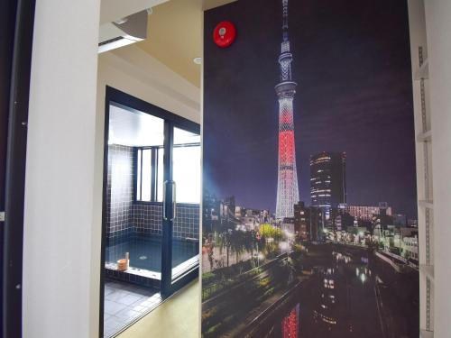 a window with a picture of the tokyo tower at HOTEL WINDS ASAKUSA Capsule Inn 浅草 in Tokyo