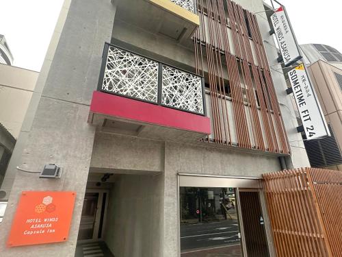 a building with a window on the side of it at HOTEL WINDS ASAKUSA Capsule Inn 浅草 in Tokyo