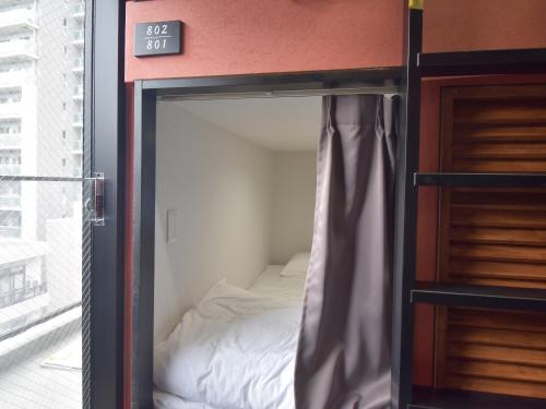 a bedroom with a bed inside of a room at HOTEL WINDS ASAKUSA Capsule Inn 浅草 in Tokyo