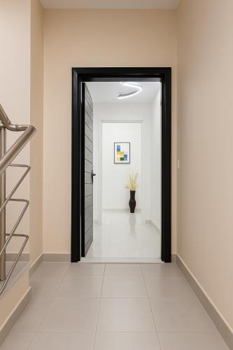 a hallway with a black door and a staircase at Villa Amor in Korçë