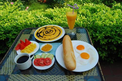 Una bandeja de desayuno con huevos y fruta y una bebida. en Tam Cốc Phương Thảo Homestay, en Ninh Binh