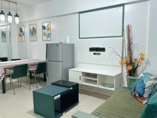 a living room with a refrigerator and a table at Apartment in Parañaque in Manila