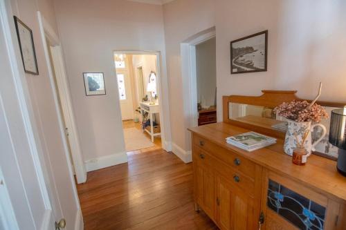 a room with a wooden dresser with a vase of flowers at Wayfarers Waypoint in Albany