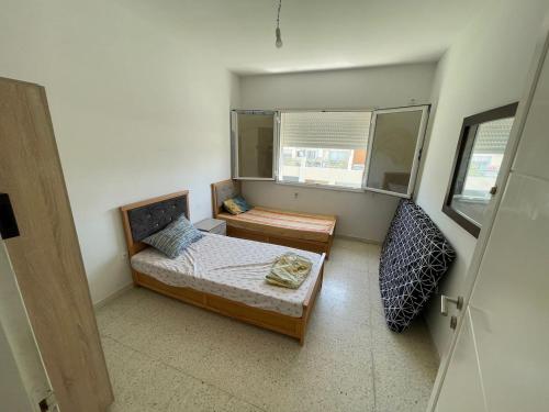 a small bedroom with a bed and a window at Appartement n20 in Nabeul