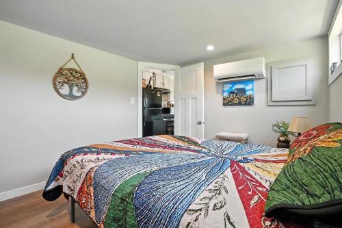 a bedroom with a bed with a colorful blanket on it at The Fluffy Cow - BRAND NEW 1 BD CABIN in Custer
