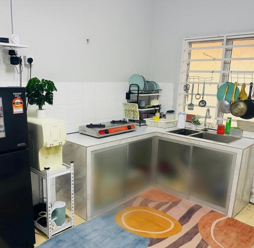a kitchen with a sink and a counter top at Ruwa Homestay - 3BR, EV Port in Jitra