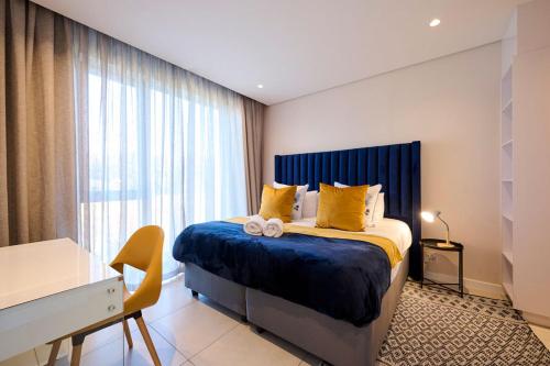 a bedroom with a large bed with yellow pillows at Sandtongate Heights in Johannesburg