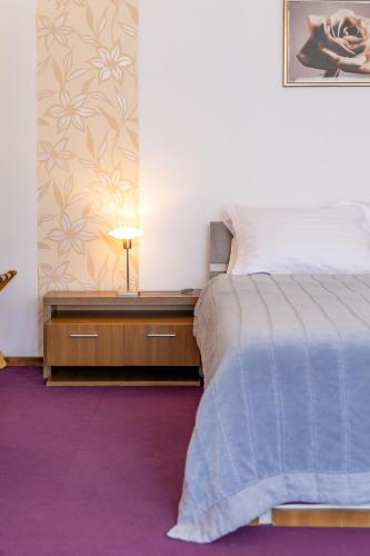 a bedroom with a bed and a table with a lamp at Hotel Roberto Sinaia in Sinaia
