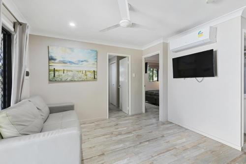 a living room with a white couch and a flat screen tv at Ingenia Holidays Townsville in Townsville