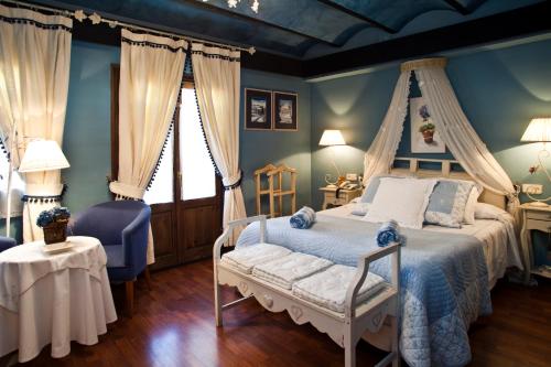 a bedroom with a canopy bed and blue walls at Hotel El Ciervo in Vielha